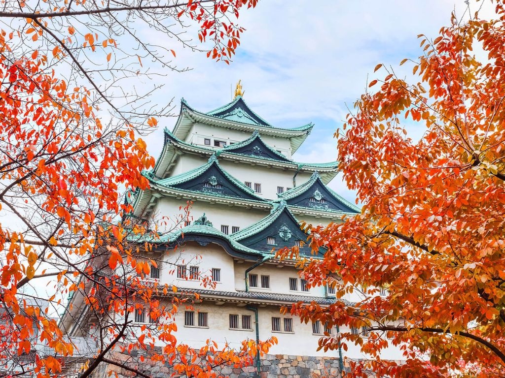 Nagoya Castle framed by autumn maple leaves